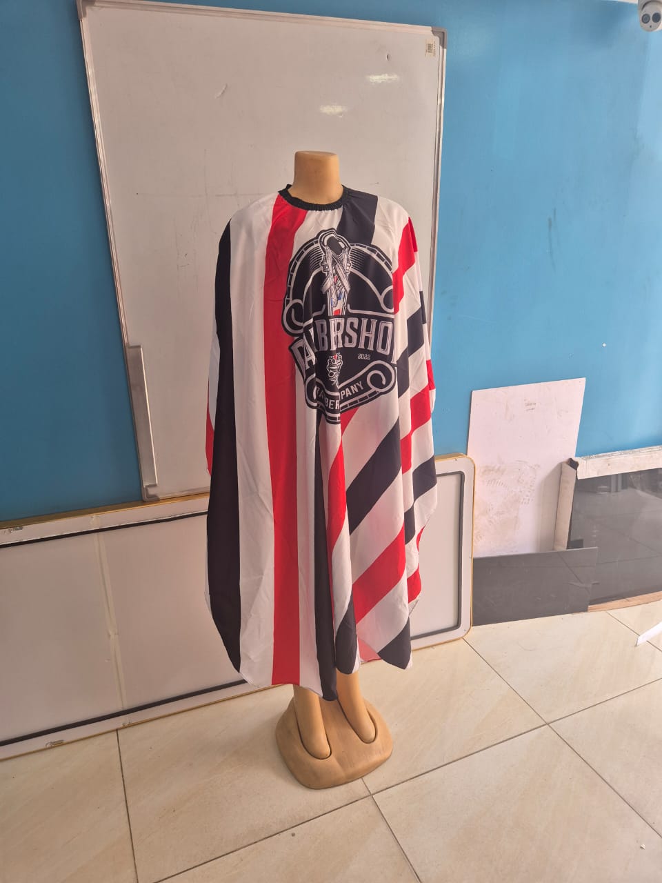 Red, black, and white striped barbershop gown with logo.
