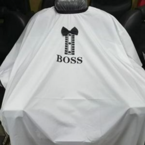 White barber gown with "Boss" written on it, high quality, easy to use, and adjustable for comfort.