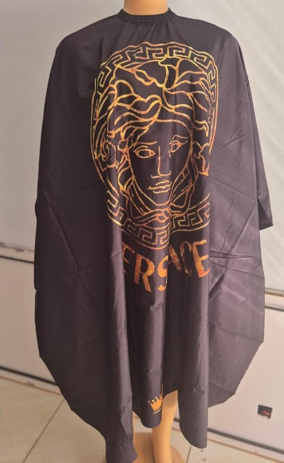 Black barber and salon gown with golden Versace-inspired design and full coverage.