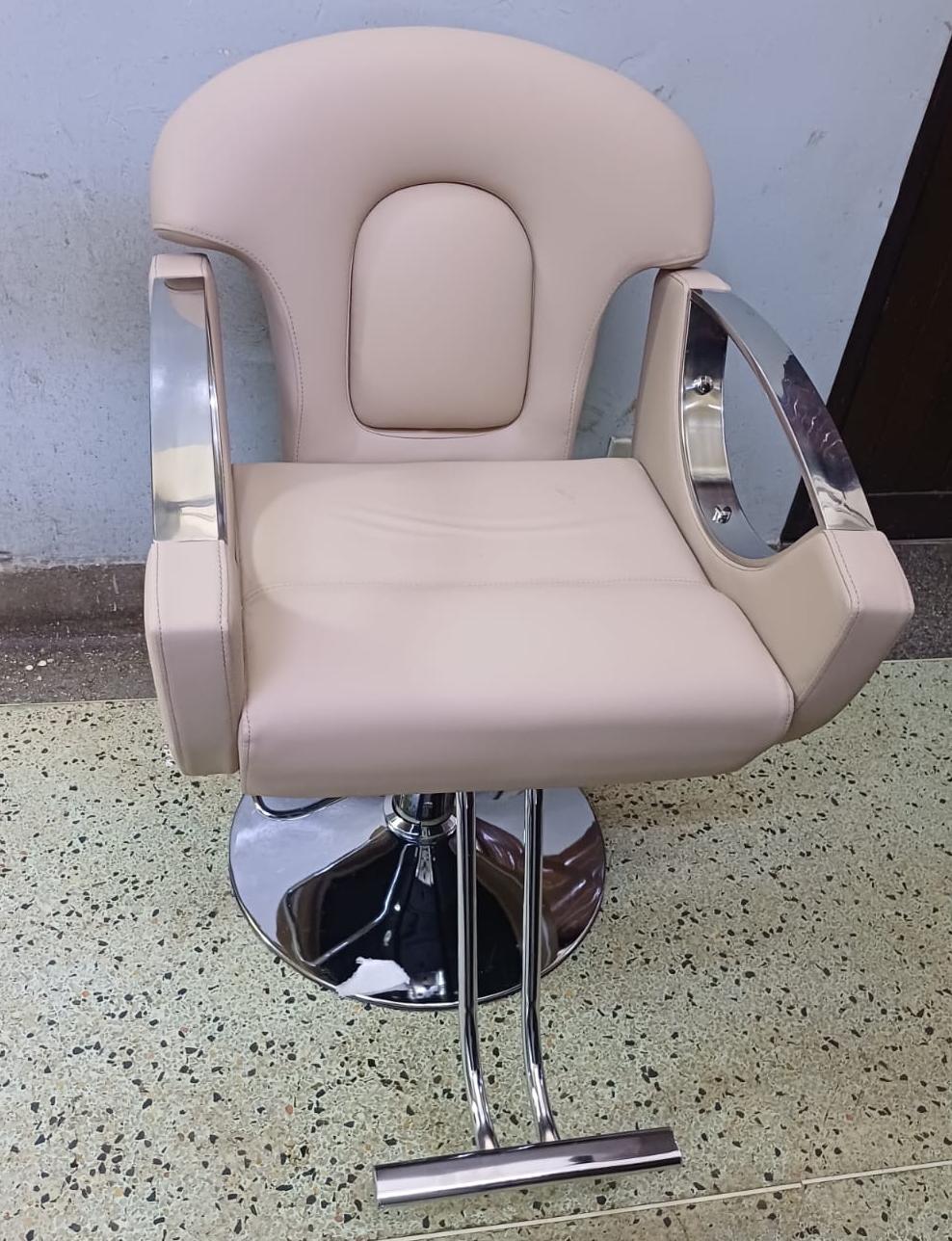 Hydraulic styling chair with chrome finish, 360° swivel and comfortable cushioning for salons and barbershops.